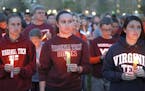 People participate in a candle light vigil Sunday, April 16, 2017, in Blacksburg Va., as part of the closing ceremony marking the 10th anniversary of 