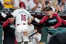 The Diamondbacks' Tucker Barnhart (16) gets a hand slap from manager Torey Luvullo after scoring against the Tigers on Sunday in Phoenix.