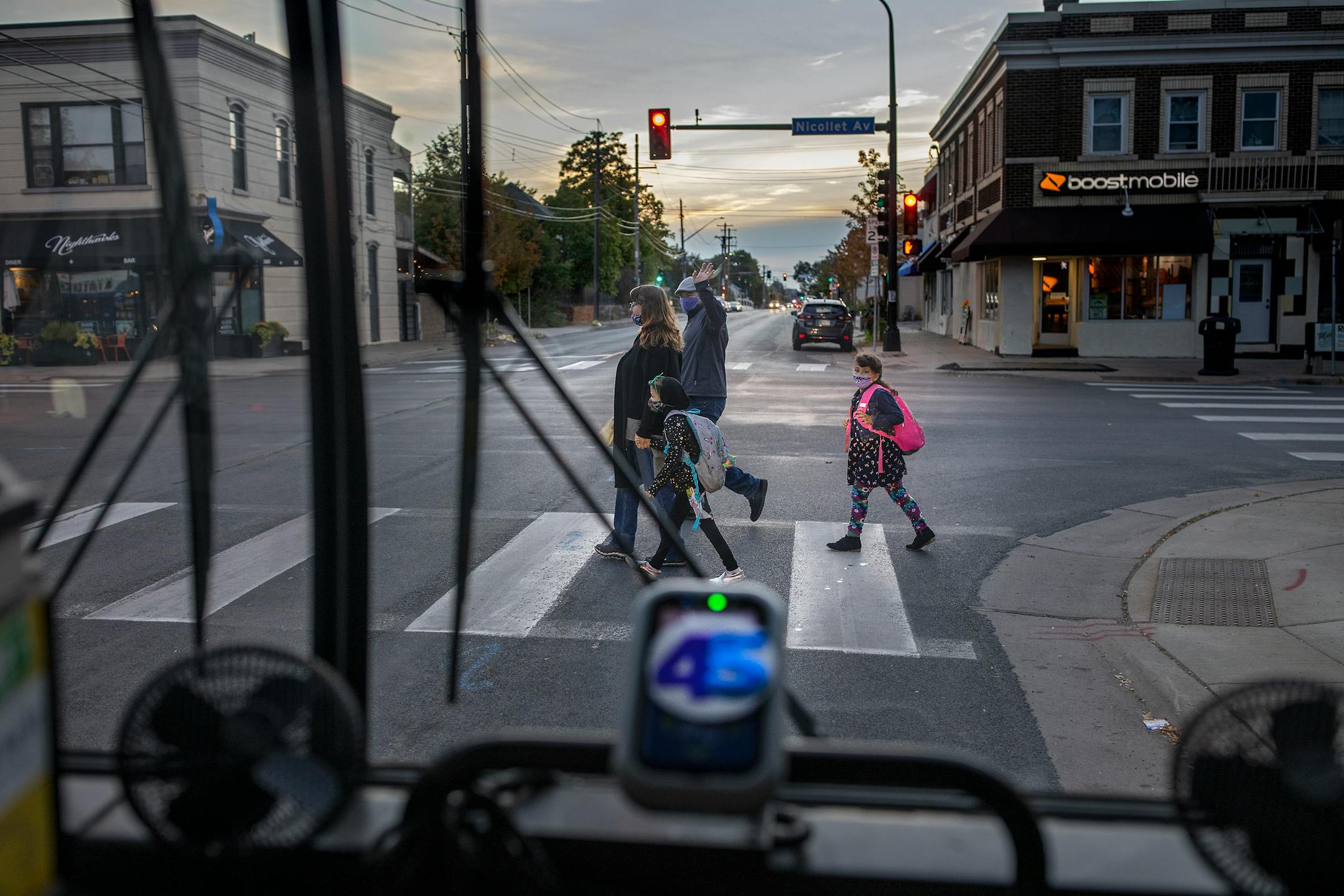 Melanie Benson's neighbors Henry and Rebekha Gertcher  with their twin daughters Emma and Zoe, 7, waved goodbye as they got off her bus Monday, October 11, 2021 between Minneapolis and St. Paul.
