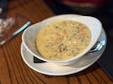 A bowl of creamy chicken wild rice soup at Grackle.