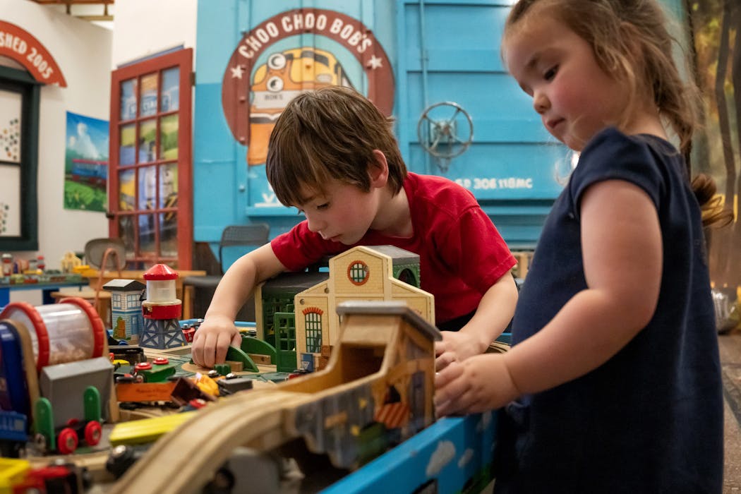 Oliver, 5, and his sister Quinn, 2, play with train toys Friday at the grand opening of Choo Choo Bob’s, which opened that day at Union Depot in St. Paul.
