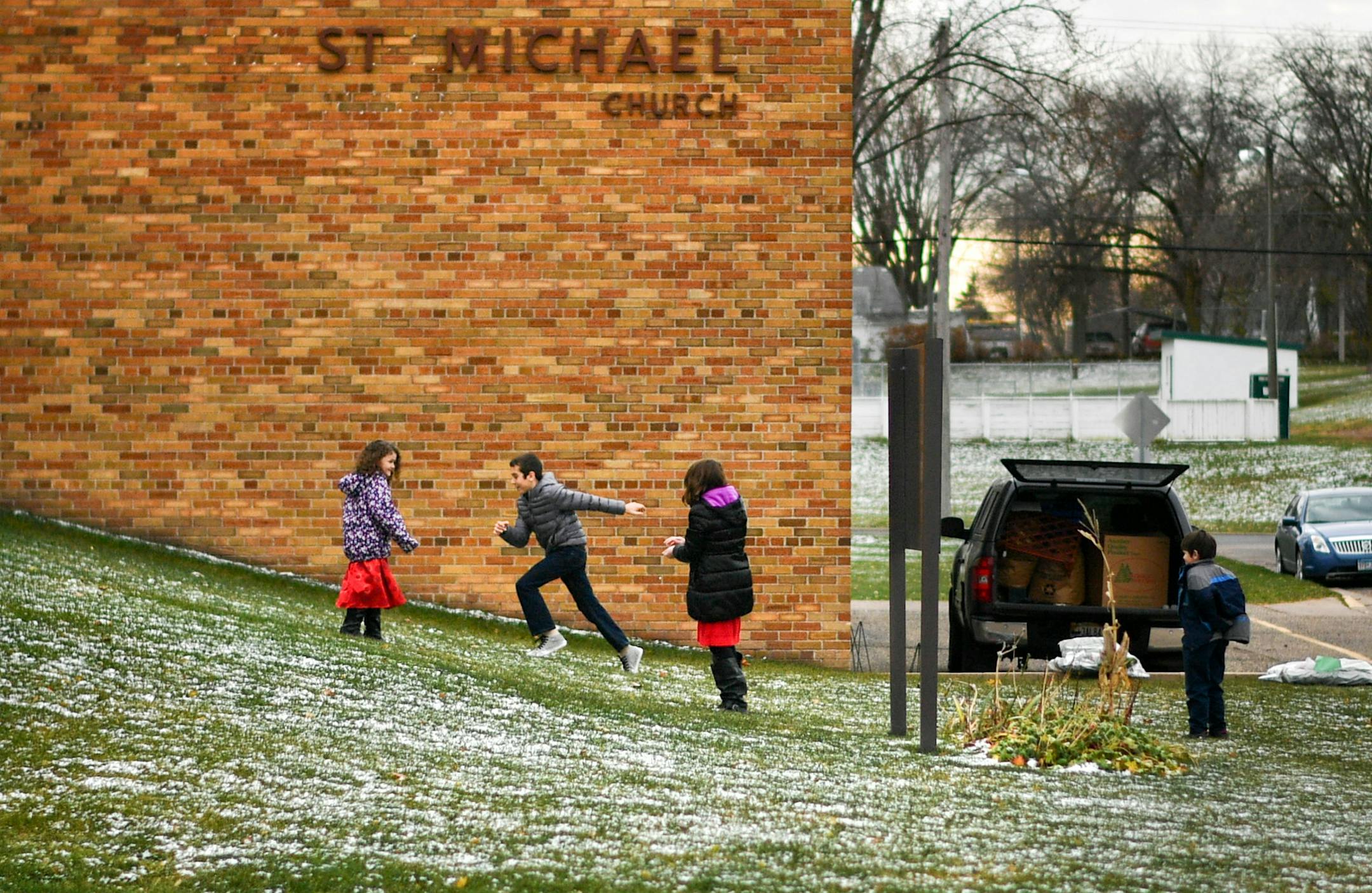 Kids played in the light snow, visible in the green grass of St. Michael Catholic Church after mass. This was the next to last mass at the church. ] GLEN STUBBE * gstubbe@startribune.com Sunday, November 20, 2016 The doors are shutting forever at St. Michael Catholic Church in West St. Paul, which will hold its last mass Nov. 27. Church leaders and parishoners heard about the closing just last month during a celebration of the church's sesquicentennial anniversary. Money-saving efforts to consol