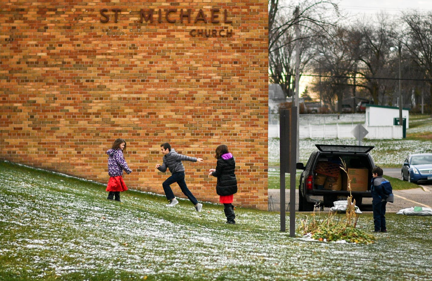 Kids played in the light snow, visible in the green grass of St. Michael Catholic Church after mass. This was the next to last mass at the church. ] GLEN STUBBE * gstubbe@startribune.com Sunday, November 20, 2016 The doors are shutting forever at St. Michael Catholic Church in West St. Paul, which will hold its last mass Nov. 27. Church leaders and parishoners heard about the closing just last month during a celebration of the church's sesquicentennial anniversary. Money-saving efforts to consol