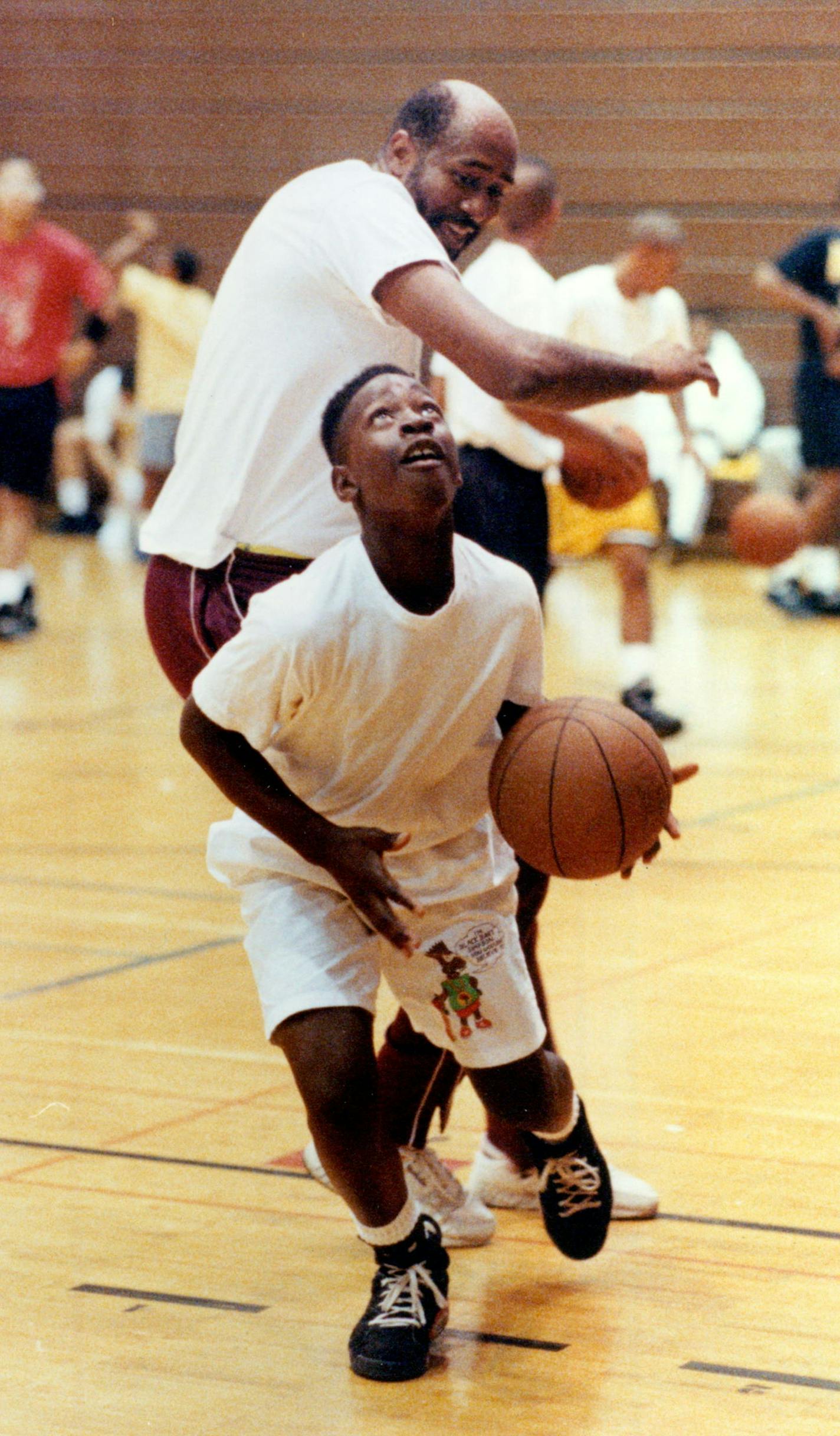 August 7, 1991 The 9th Annual Turner Washburn Co-Ed Mini-Camp held at Minneapolis Washburn High School. The mini-camp covers basketball fundamentals, personal development, career seminars and includes special awards and meals. Twelve-year-old Kolliepaye Kpowulu drives around Clyde Turner, the creator of the basketball camp, as the two played a little one-on-one before the session got underway. August 8, 1991 Joey McLeister, Minneapolis Star Tribune