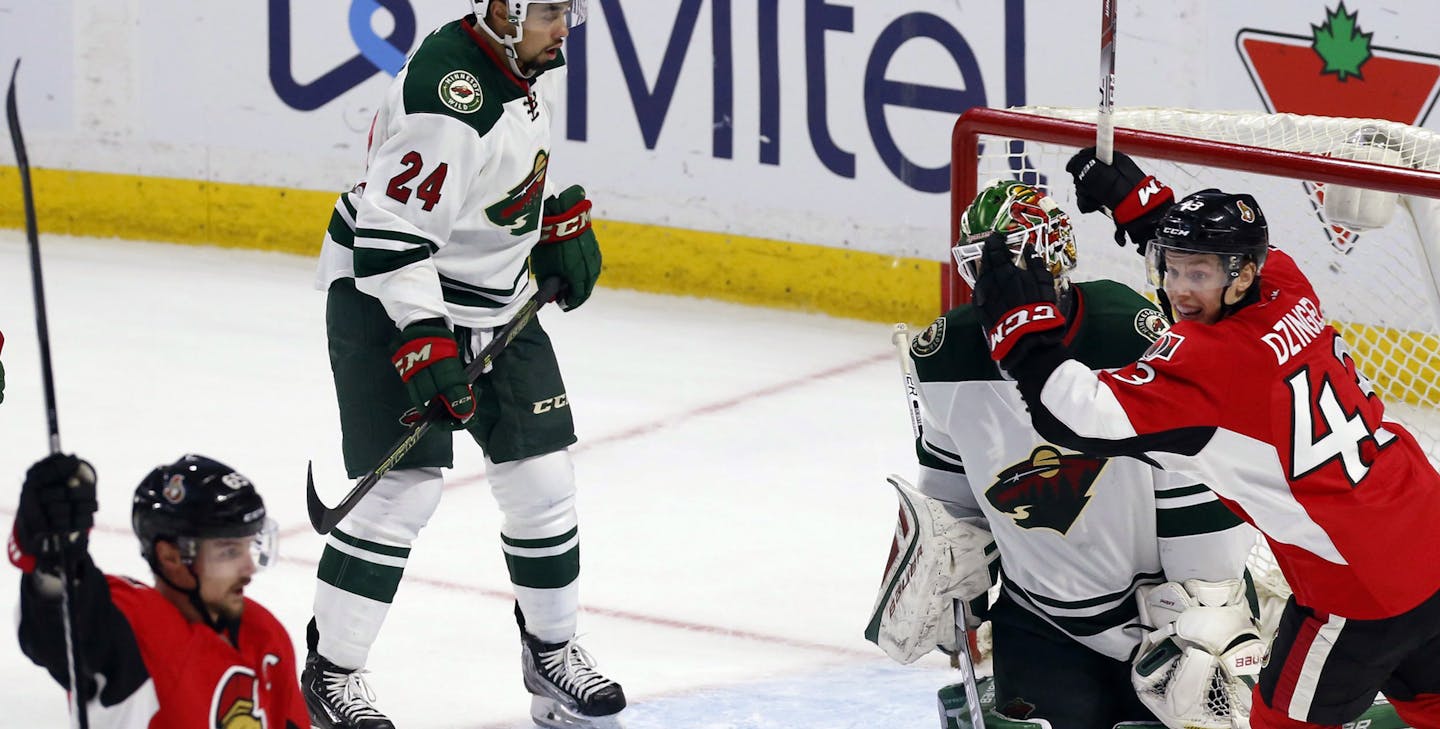 Minnesota Wild goaltender Devan Dubnyk (40) and teammate Matt Dumba (24) react as Ottawa Senators' Erik Karlsson, front left, celebrates his overtime goal with teammate Ryan Dzingel (43) in an NHL hockey game Tuesday, March 15, 2016, in Ottawa, Ontario. (Fred Chartrand/The Canadian Press via AP)