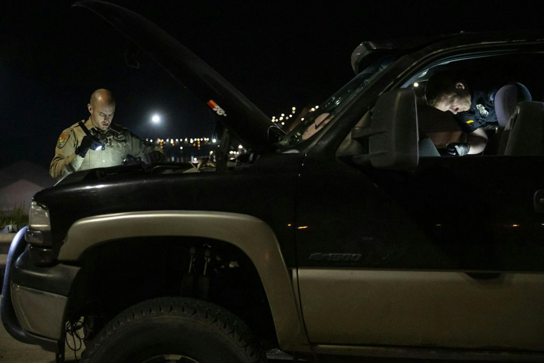 (Left) Deputy Ben Fye from the St. Louis County Sheriff's Office and Officer Jake Moldenhauer from the Duluth Police Department search through a pickup truck suspected of having crystal meth hidden inside. Dayshift officers from the Duluth Police Department received intel early on Wednesday that a pickup truck matching this description and license plate would be transporting crystal meth later that night. Approximately one pound of meth was found in the truck.