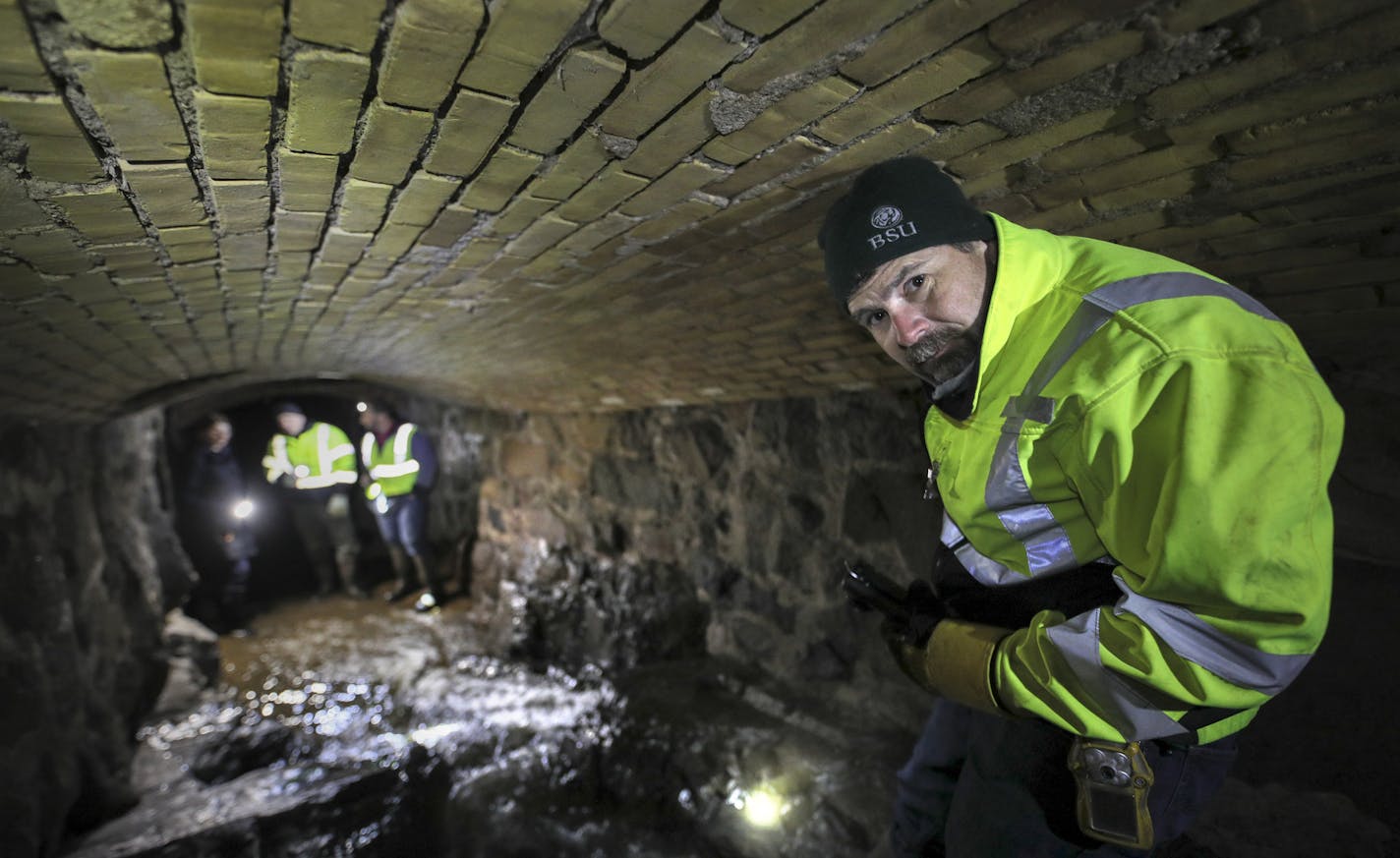 Todd Carlson, program coordinator for Duluth's engineering department, navigates a storm tunnel under the city.