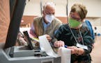 John Keenan, left, and Kathie Trotta, Duluth’s 11th precinct co-head polling judges, read off the in-person ballot counts for the presidential and U
