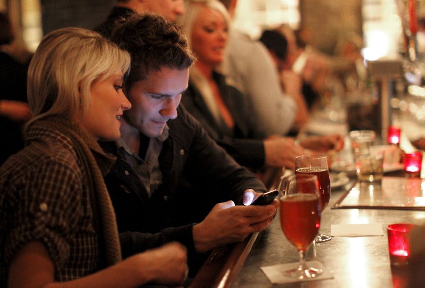 Kyle Meehan and Katie Rolbiecki text by cell phone at Bar La Grassa 800 North Washington Ave, Minneapolis, MN 55401