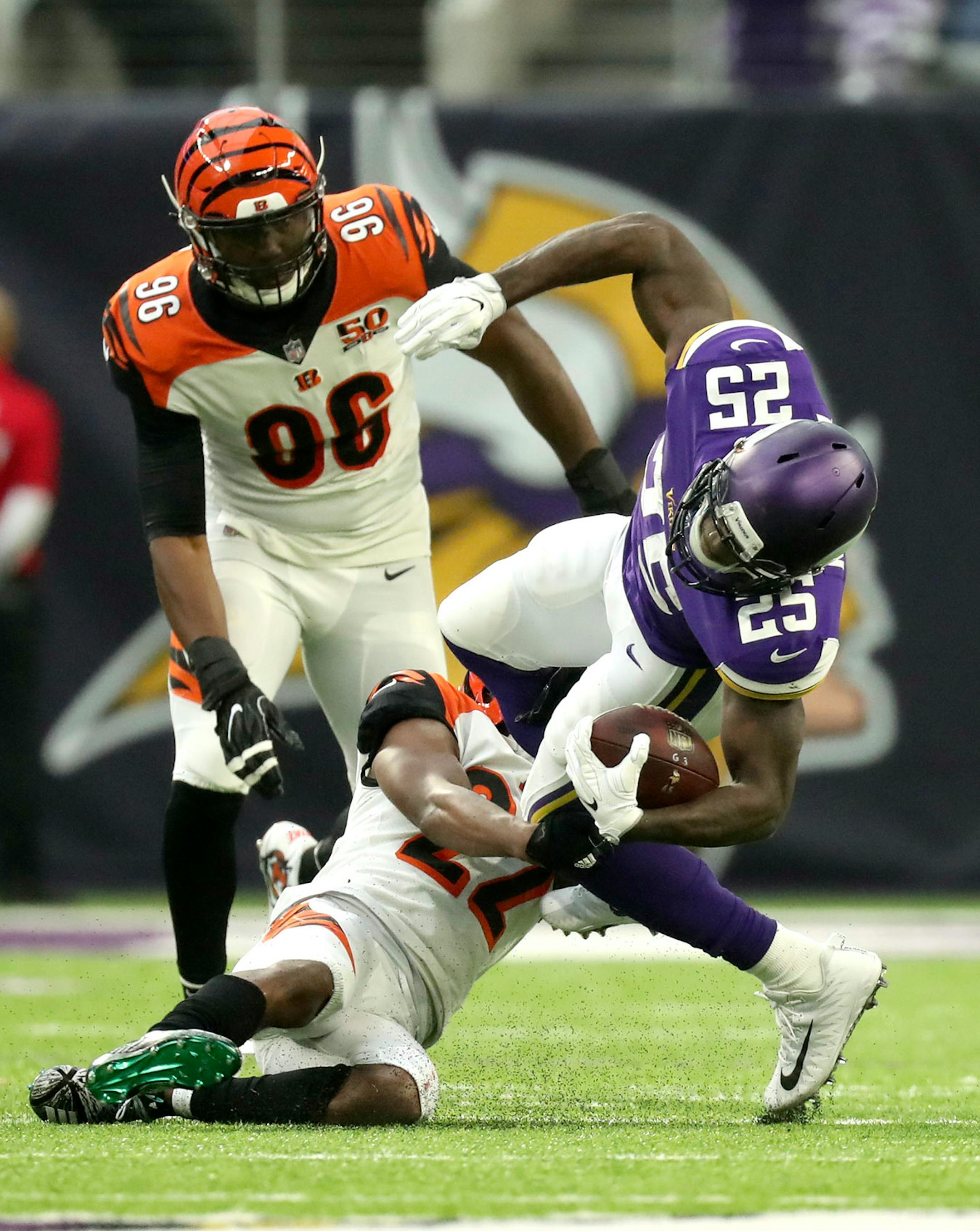 Vikings running back Latavius Murray (25) was pulled down by Cincinnati Bengals cornerback William Jackson (22) in the first half Sunday as defensive end Carlos Dunlap followed in pursuit.