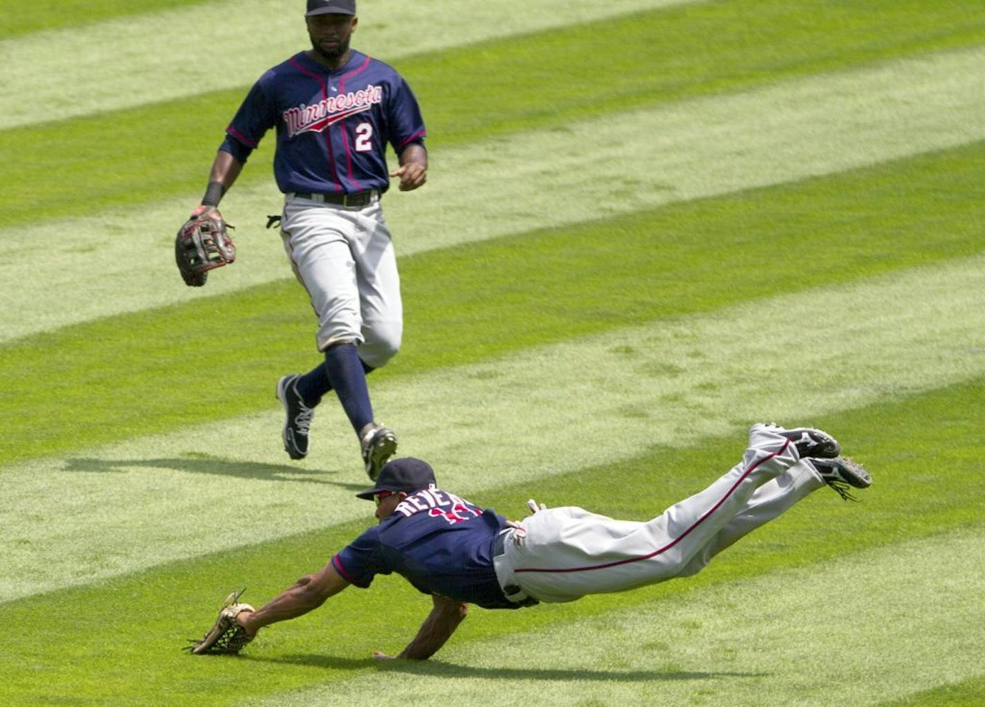 Minnesota Twins' right fielder Ben Revere dives but can't catch ball hit by the Chicago White Sox' Kevin Youkilis in the third inning of a baseball game in Chicago on Wednesday, July 25, 2012. Center fielder Denard Span looks on.