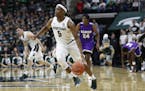 Michigan State guard Cassius Winston (5) brings the ball up court during the second half of an NCAA college exhibition basketball game against Albion,
