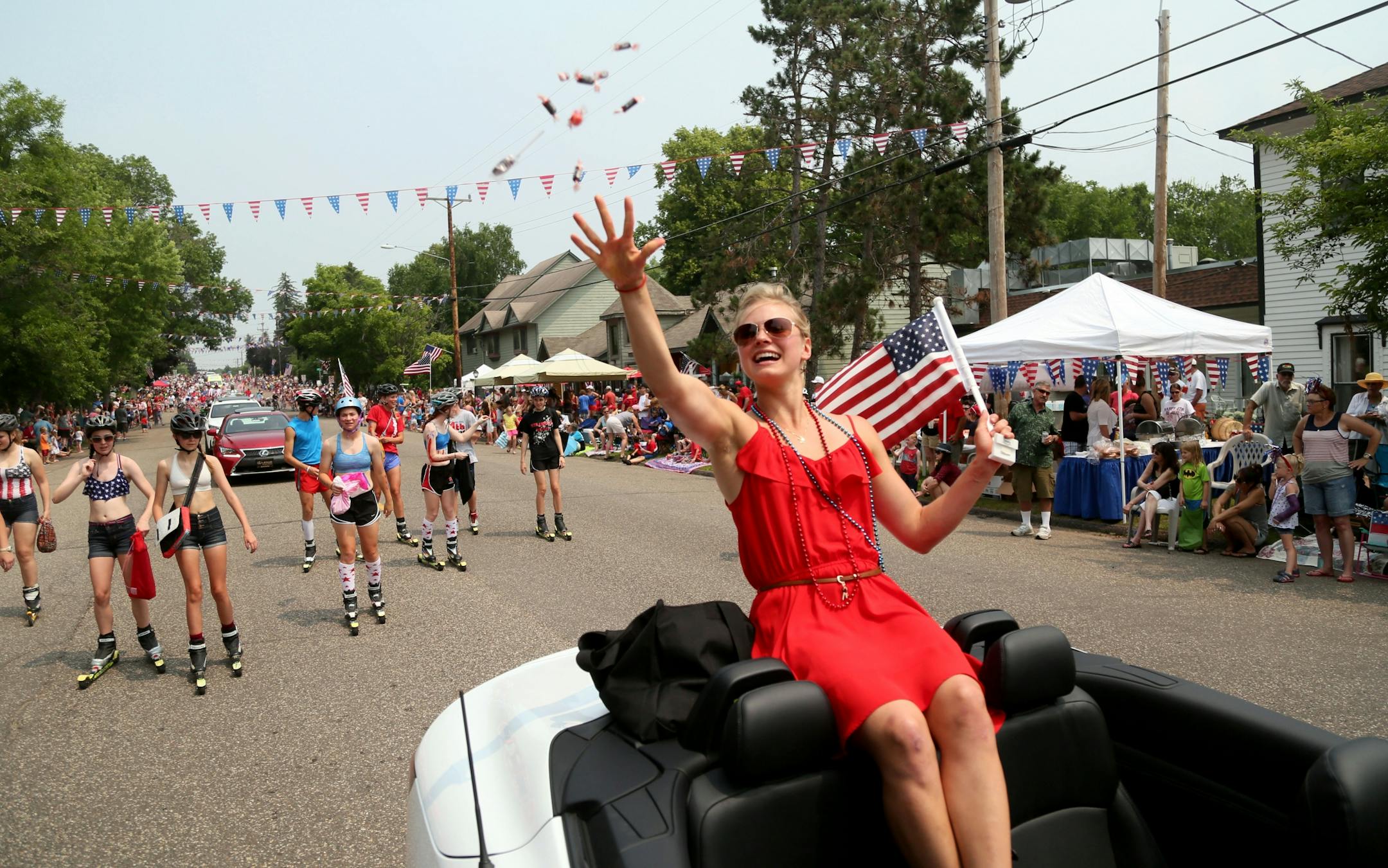 Olympic cross country skier Jessie Diggins, who is from Afton, throws candy while headed down the main drag in downtown Afton, Minn., during the 4th of July parade Saturday, July 4, 2015.