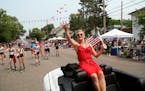Olympic cross country skier Jessie Diggins, who is from Afton, throws candy while headed down the main drag in downtown Afton, Minn., during the 4th o