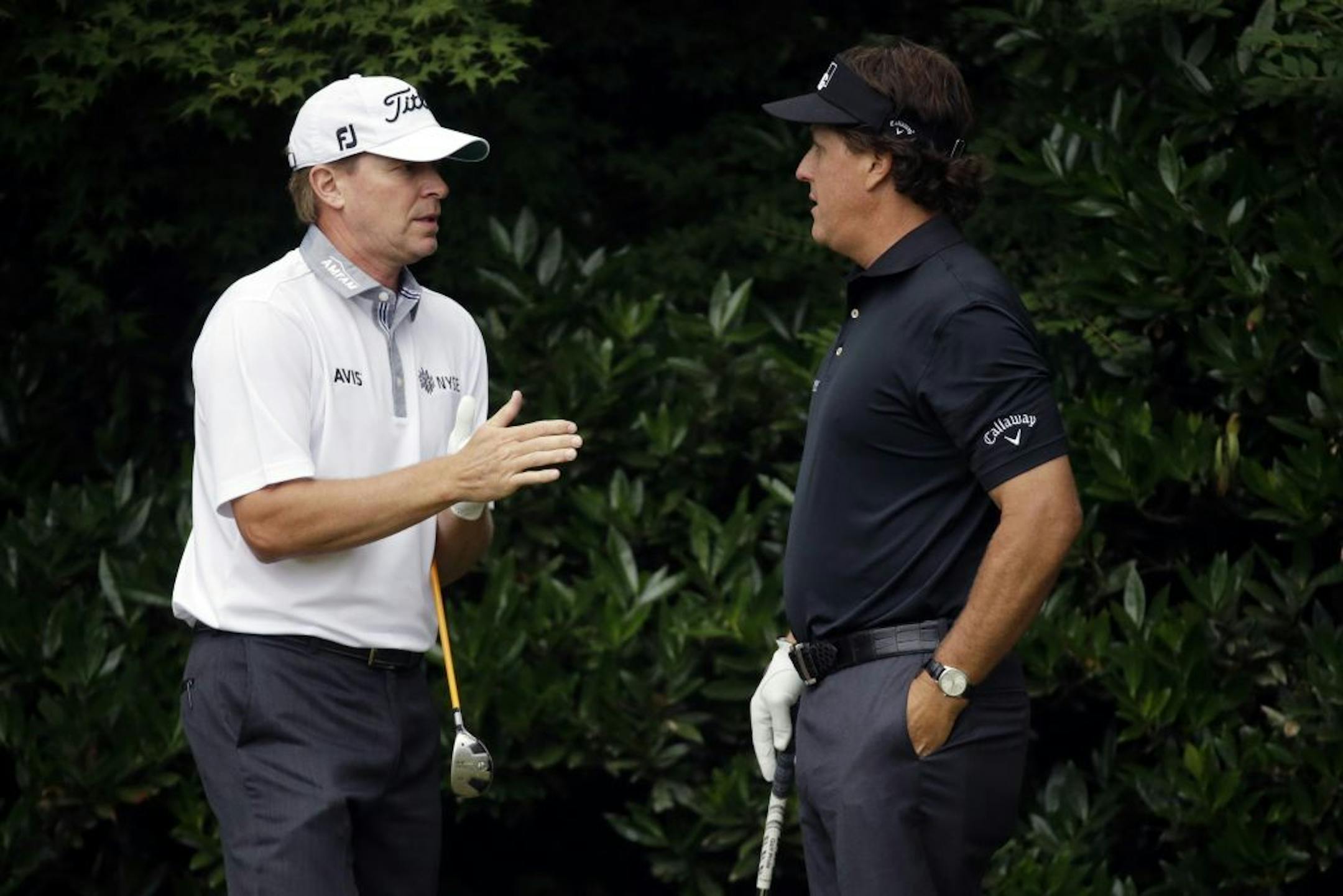 Steve Stricker, left, and Phil Mickelson talk before teeing off on the 11th hole during the first round of the U.S. Open golf tournament at Merion Golf Club, Thursday, June 13, 2013, in Ardmore, Pa.