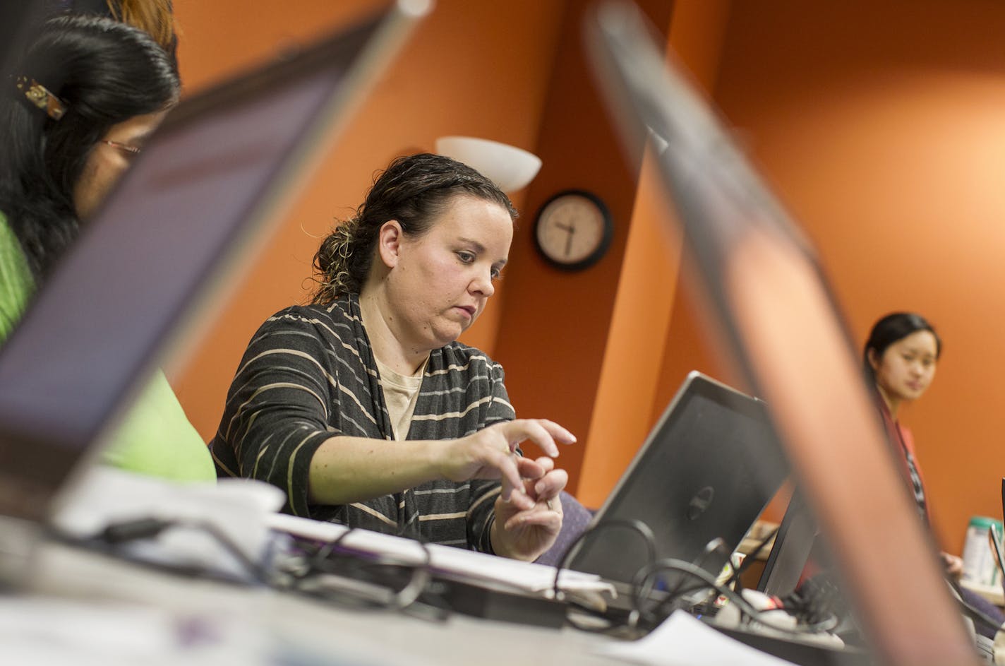 Outreach program supervisor Sara Casey, center, helps Minnesotans sign up for MNsure health benefits in St. Paul on Dec. 21, 2013.