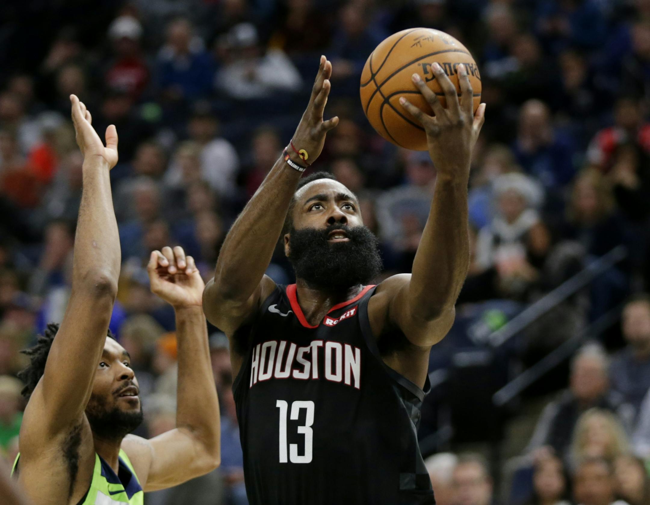 Houston Rockets guard James Harden (13) shoots on against Minnesota Timberwolves guard Keita Bates-Diop in the third quarter during an NBA basketball game Saturday, Nov. 16, 2019 in Minneapolis. The Rockets defeated the Timberwolves 125-105 with Harden scoring a game-high 49 points.