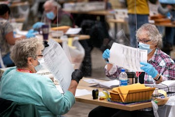 Ramsey County election judges Nancy Matthews and Kathy Lair checked ballots. After they are removed from envelopes, they are scanned by computer, then