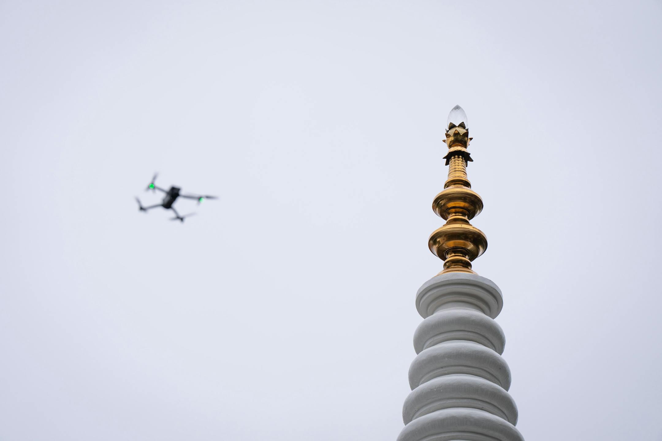 A drone circled as the brass pinnacle is unveiled Friday, Oct. 6, 2023 Minneapolis, Minn. This Stupa Unveiling marks a significant milestone in the history of Minnesota Buddhist Vihara and is an occasion of great joy and appreciation. A Stupa is a large white cement dome topped with a brass pinnacle. A sacred stupa is a physical structure in which a relic of the Buddha, enlightened beings, or holy books is enshrined. It creates an opportunity for people to circumambulate and cultivate positive vibration and spiritual development. ] GLEN STUBBE • glen.stubbe@startribune.com