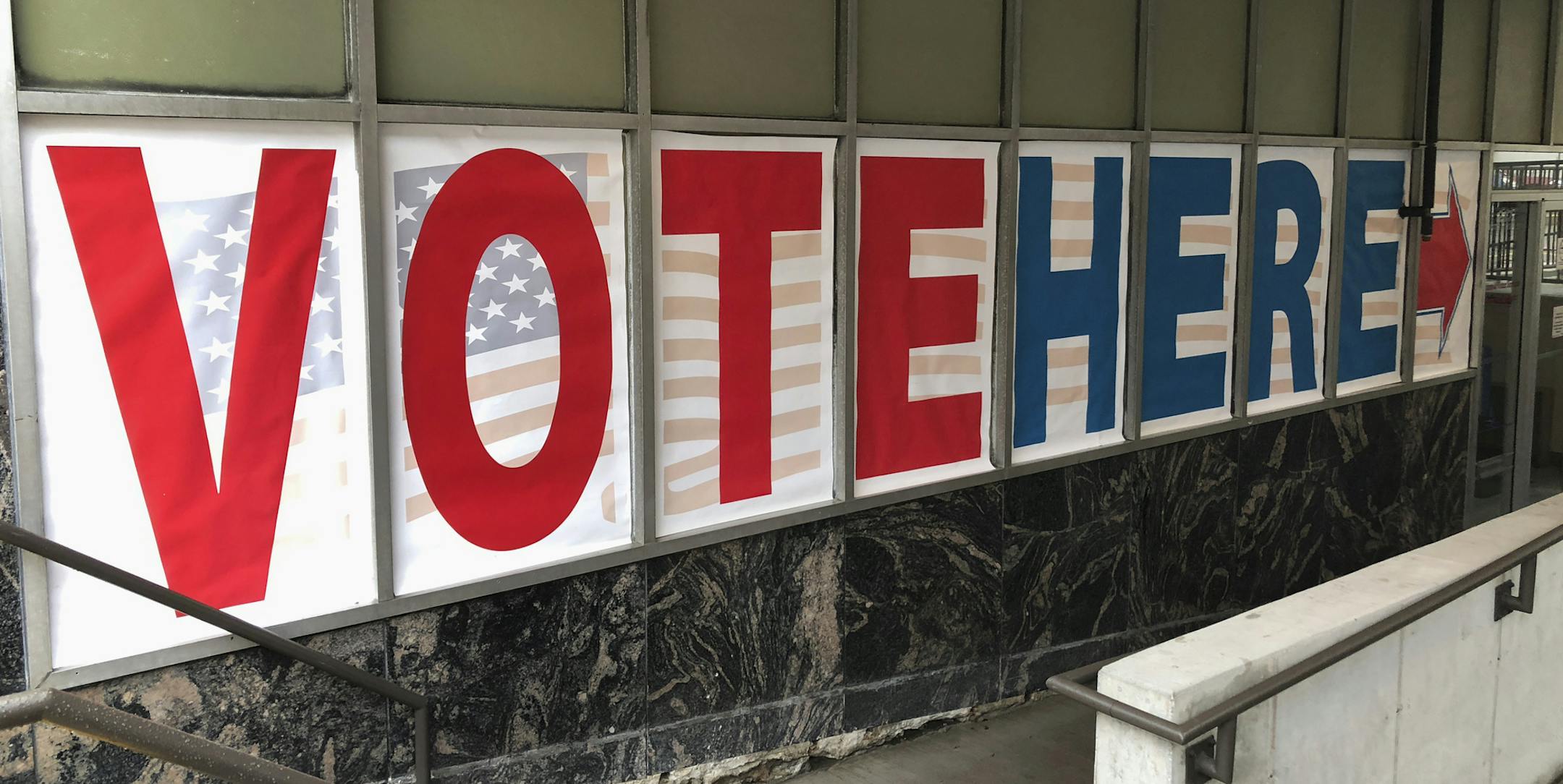 A "Vote Here" sign marks the entrance on Thursday, Sept. 20, 2018, to an early voting station in downtown Minneapolis for Friday's opening of early voting in Minnesota. Minnesota and South Dakota are tied for the earliest start in the country for early voting in the 2018 midterm elections. (AP Photo)