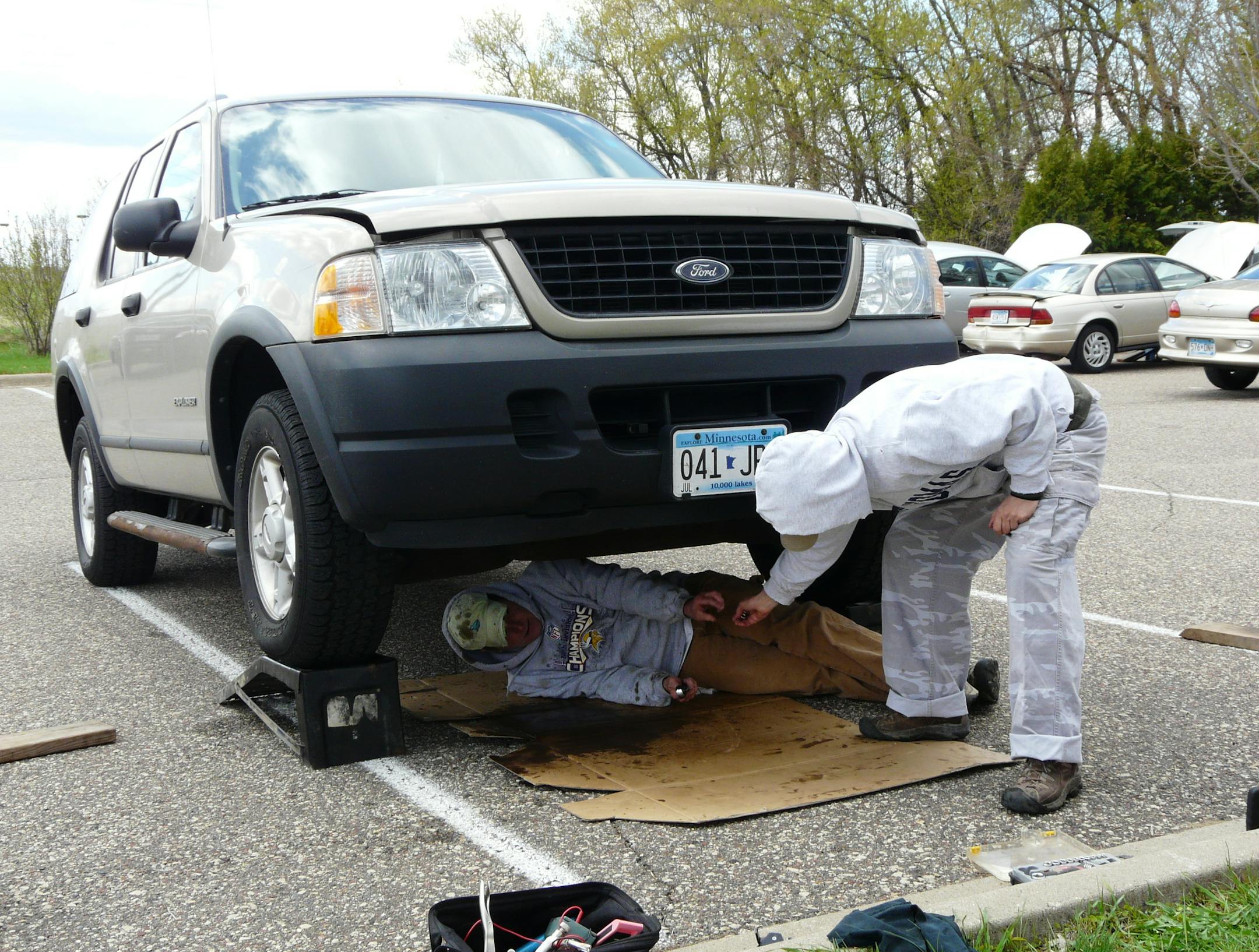 Photo by David Peterson Church members Jody Gerst (under car) and Nancy Haddorff worked on oil changes.