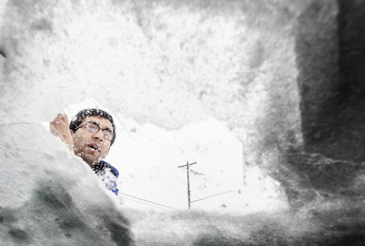 Manik Tandon, of St. Paul, cleared ice and snow off of his windshield during a snowstorm on Feb. 7, 2019.