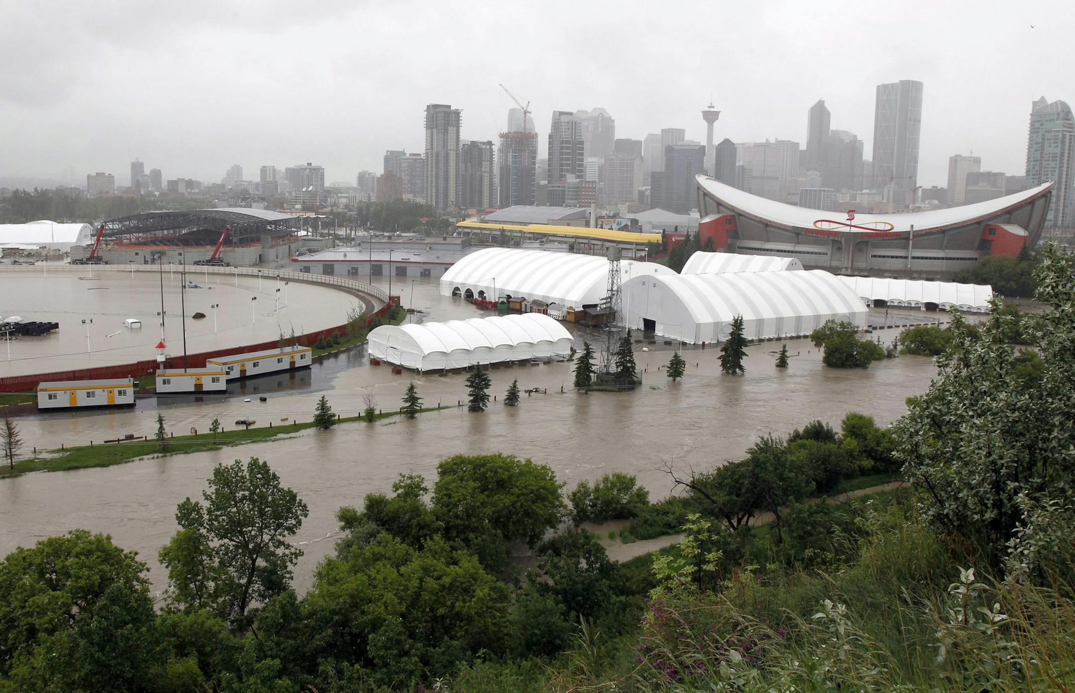 The Calgary Stampede grounds and Saddledome are flooded due to the heavy rains in Calgary, Alberta, Canada, on Friday June 21, 2013. Flooding forced the western Canadian city of Calgary to order the evacuation of the entire downtown area on Friday, as the waters reached the 10th row of the city&#xed;s hockey arena. Communities throughout southern Alberta are dealing with overflowing rivers that have washed out roads and bridges, inundated homes and turned streets into dirt-brown tributaries. Abo