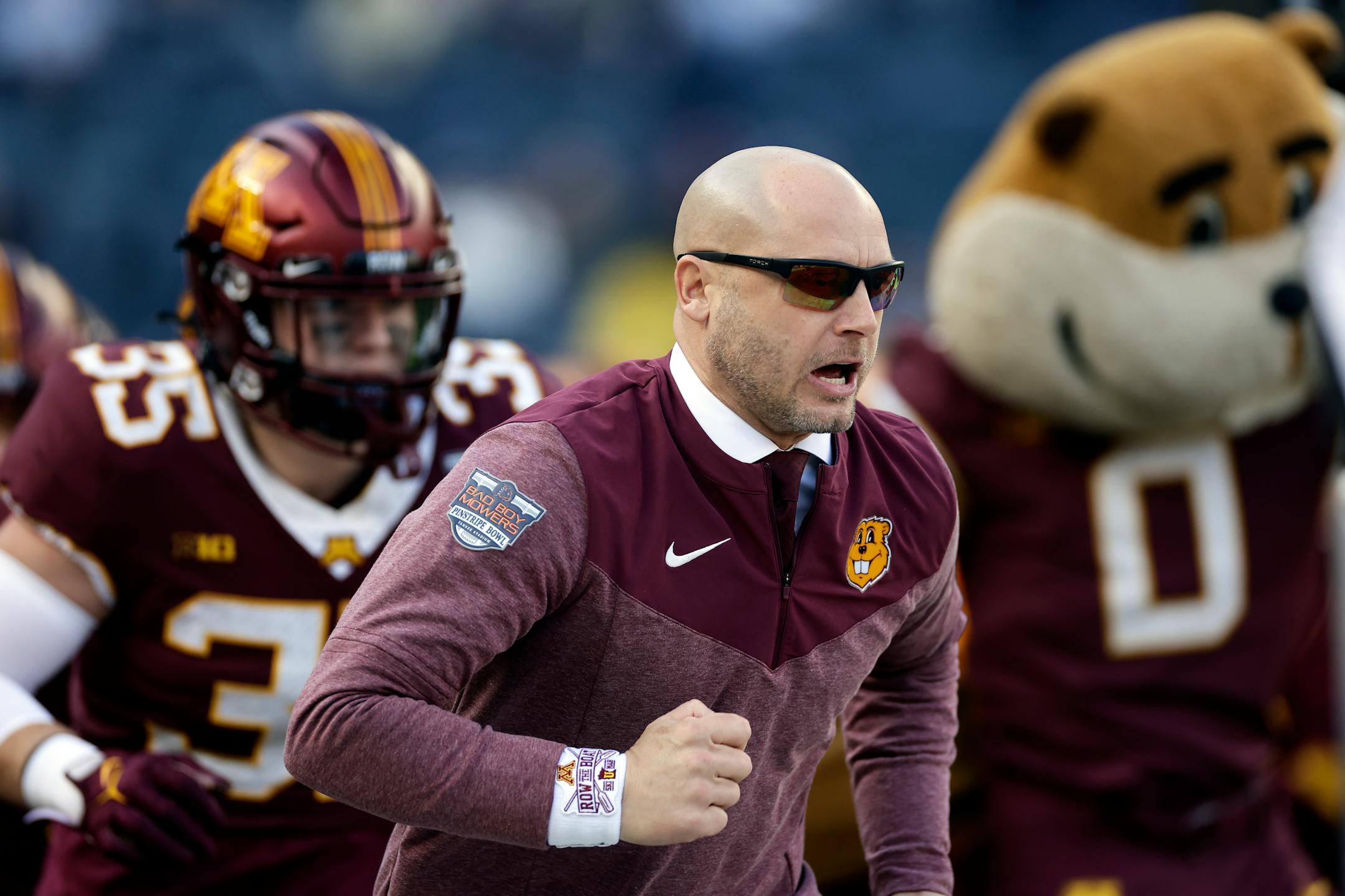Minnesota head coach P. J. Fleck leads his team onto the field to face Syracuse in the Pinstripe Bowl.