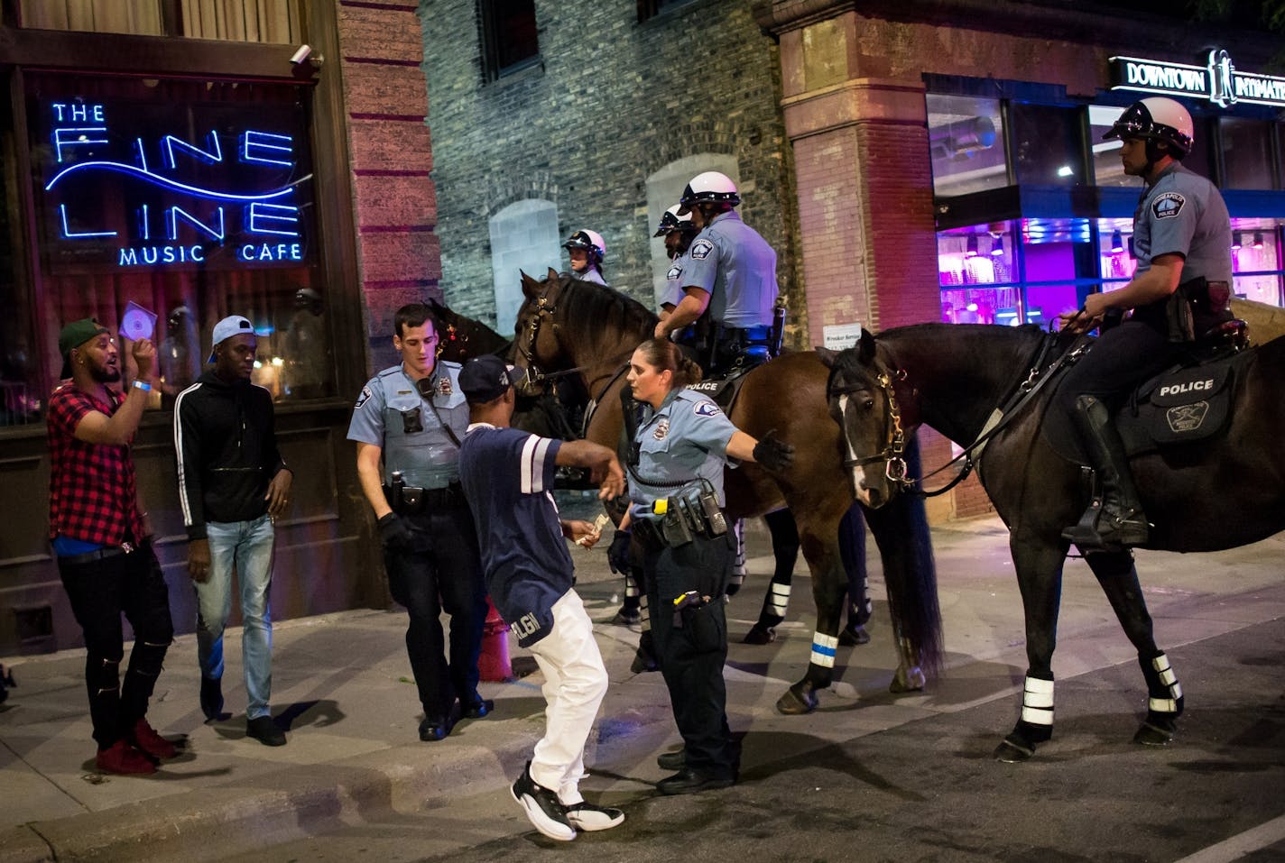 Minneapolis Police officers worked on clearing a group of men from First Avenue North in downtown Minneapolis after closing time early Sunday morning.