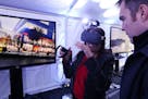 Taylor Cupp with Mortenson showed Joselyn Raymundo a virtual reality walkthrough of Discovery Square in a heated tent following an outdoor groundbreak