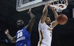 Minnesota's Jordan Murphy dunks past Middle Tennessee State's Giddy Potts during the second half of an NCAA college basketball tournament first round 