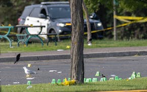 Evidence markers from different shell casings mark the ground as Minneapolis Police Forensics Division take in evidence after a shooting claimed the l