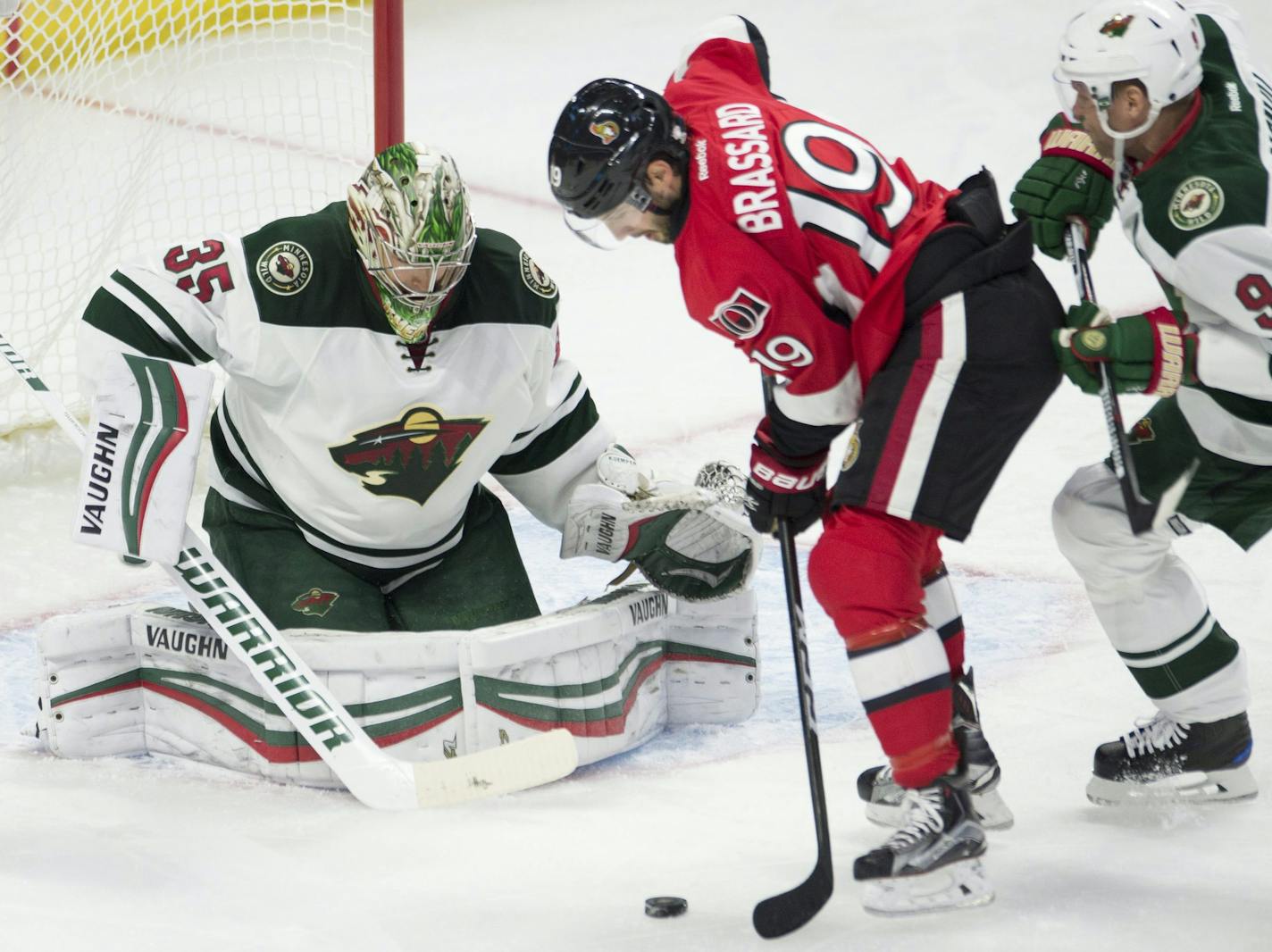 Minnesota Wild center Mikko Koivu, right, pressures Ottawa Senators center Derick Brassard, who shoots on goalie Darcy Kuemper during the first period of an NHL hockey game Sunday, Nov. 13, 2016, in Ottawa, Ontario. (Adrian Wyld/The Canadian Press via AP)