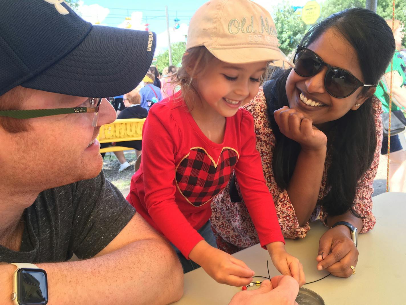 Evelyn Mueller made a cross necklace with her parents Matt and Zion Mueller at Crossroads Ministries at the Minnesota State Fair. Crossroads is one of three places offering Sunday services, as well as weekday events.