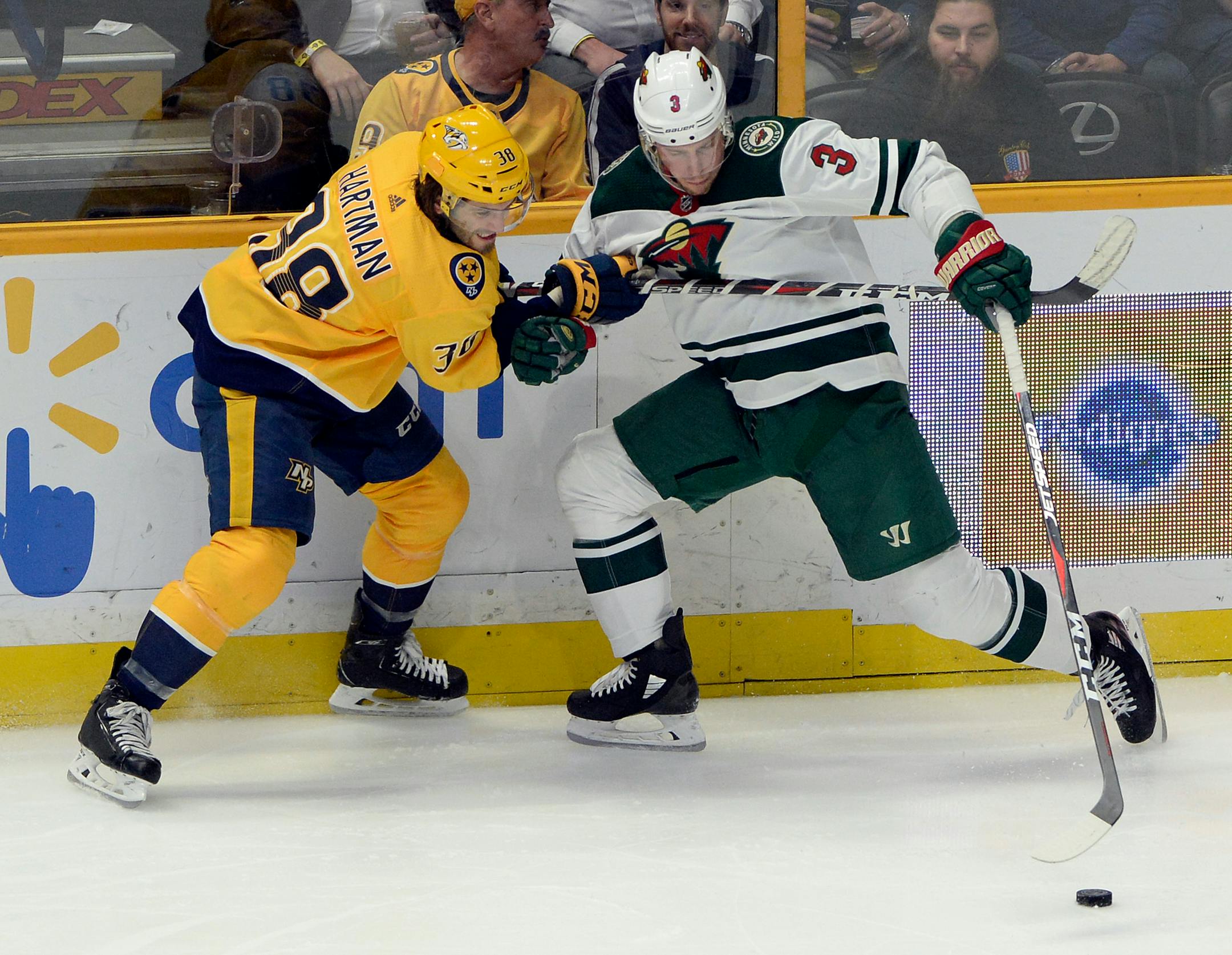 Nashville Predators right wing Ryan Hartman (38) tries to stop Minnesota Wild center Charlie Coyle (3) from getting control of the puck during the second period of an NHL hockey game Tuesday, March 27, 2018, in Nashville, Tenn. (AP Photo/Mark Zaleski)