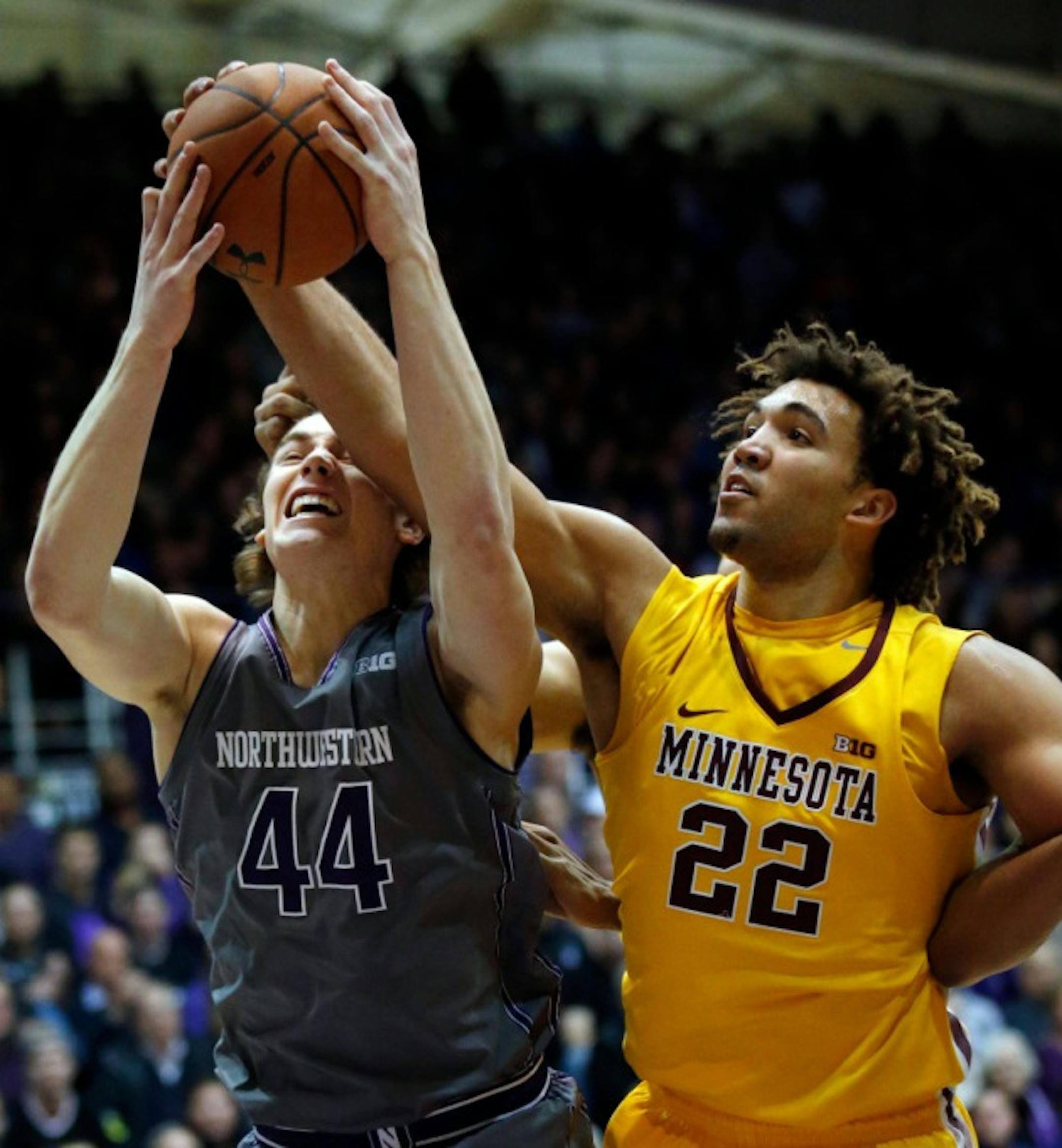 Northwestern forward Gavin Skelly, left, battles for a rebound against Minnesota center Reggie Lynch during the first half. (AP Photo/Nam Y. Huh)