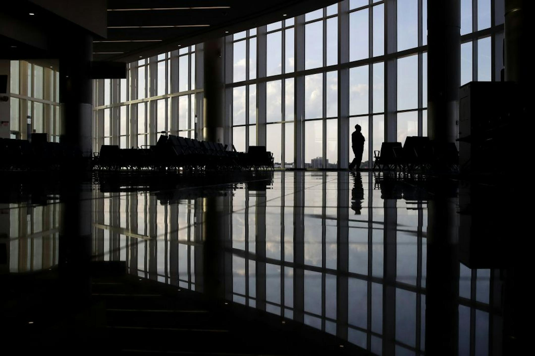 FILE - In this Monday, June 1, 2020 file photo, a woman looks through a window at a near-empty terminal at an airport in Atlanta. Anxiety and depression are rising among Americans compared with before the pandemic, research suggests. Half of those surveyed in a study released on Wednesday, Sept. 2, 2020, reported at least some signs of depression.