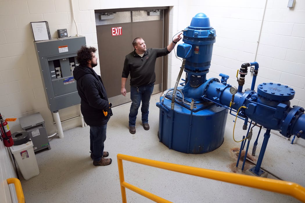 Winona water department superintendent Aaron Hauser and natural resources and sustainability coordinator John Howard looked over a well pump for the city of Winona’s drinking water Jan. 18. The drinking water plant is one of the city's biggest energy users.