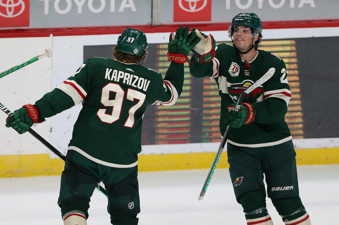 Minnesota Wild's Kirill Kaprizov (97) high-fives Kevin Fiala (22) after Kaprizov scored a goal against the St. Louis Blues during the third period of an NHL hockey game Thursday, April 29, 2021, in St. Paul, Minn. St. Louis won 5-4 in overtime. (AP Photo/Stacy Bengs)