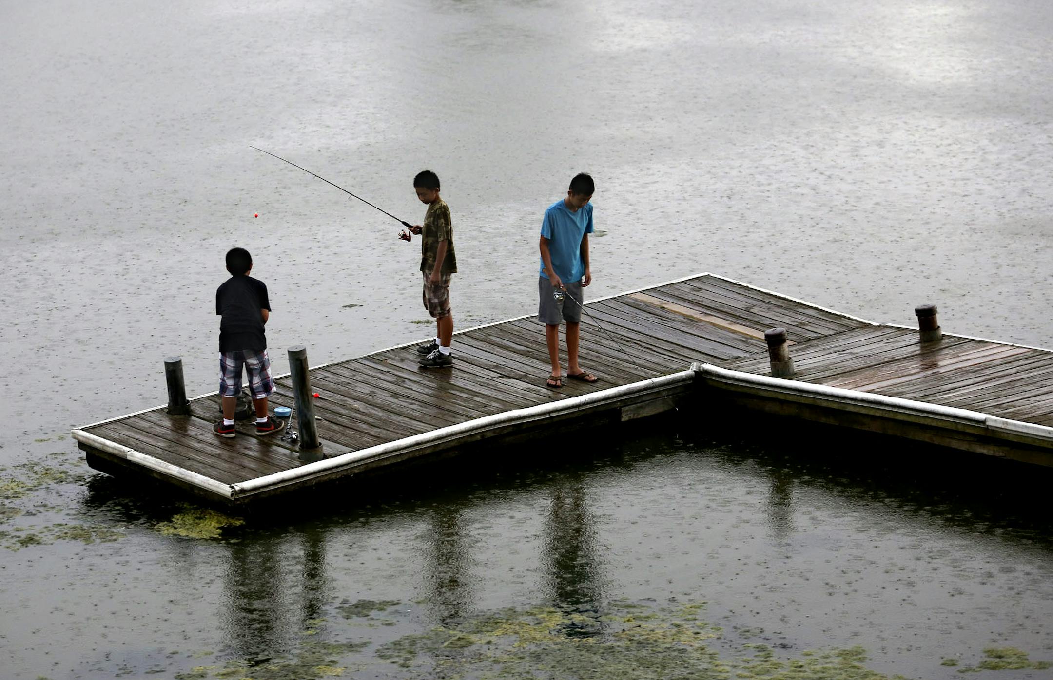 Boys tried to catch one more fish as the rain came down near the Como Park Pavilion in St. Paul Tuesday.