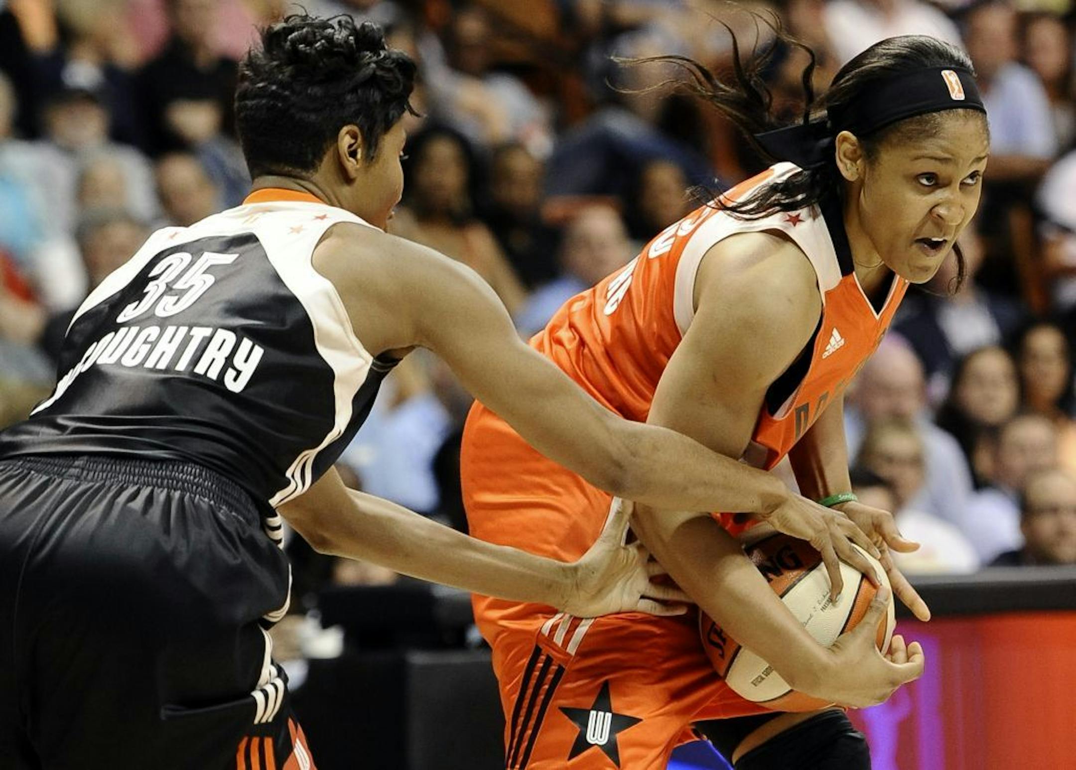East's Angel McCoughtry, left, of the Atlanta Dream, pressures West's Maya Moore, of the Minnesota Lynx, during the first half of the WNBA All-Star basketball game in Uncasville, Conn., Saturday, July 27, 2013.