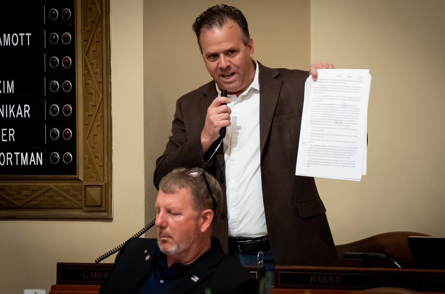 Rep. Pat Garofalo, R-Farmington, holds up a copy of the Uber Lyft bill and objected to a provision on Sunday.