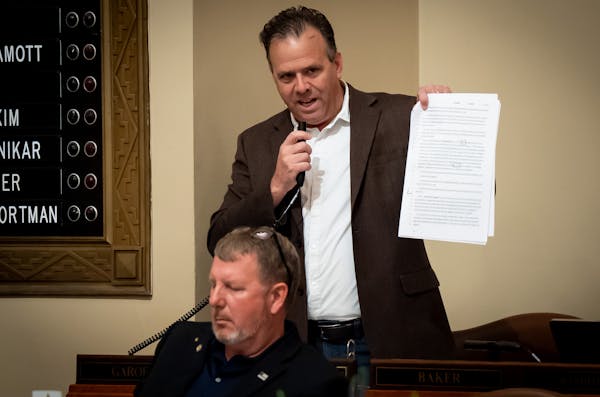 Rep. Pat Garofalo, R-Farmington, holds up a copy of the rideshare bill and objected to a provision on Sunday.