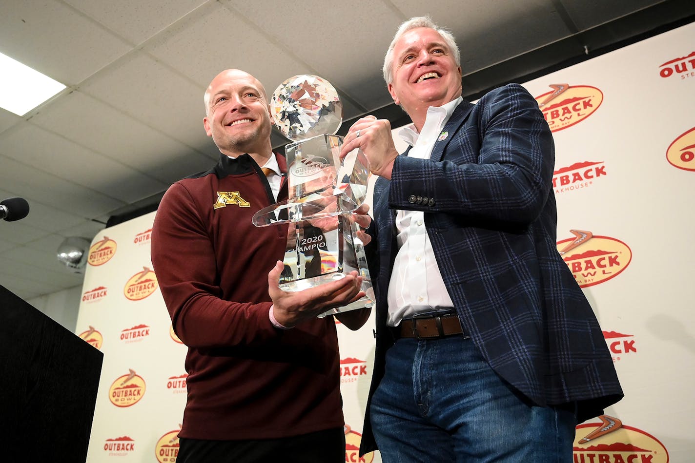 Minnesota Gophers head coach PJ Fleck posed for photos with the Outback Bowl trophy alongside Blooming Brand CEO David Deno.