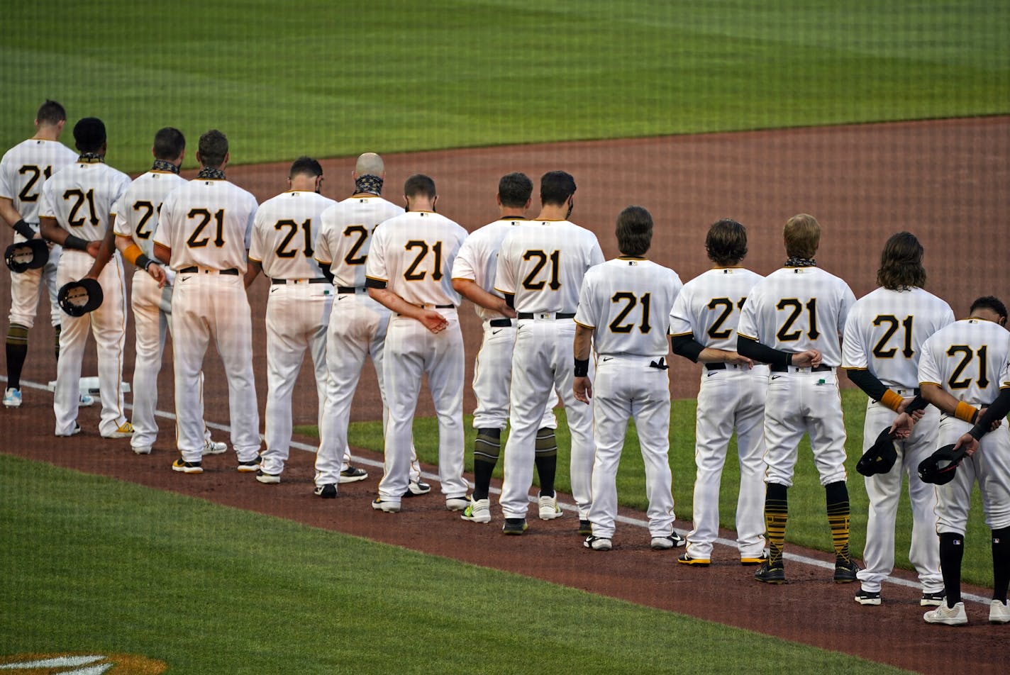 The Pittsburgh Pirates, all wearing Roberto Clemente's No. 21 for Roberto Clemente Day, watch a tribute to the Pirates Hall of Fame right fielder before the team's baseball game against the Chicago White Sox in Pittsburgh, Wednesday, Sept. 9, 2020. (AP Photo/Gene J. Puskar)