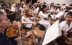 Violin players Christa Morera, from right, and Danielle Gonzalez of the Orquesta Sinfonica Juvenil del Conservatorio takes part in a side-by-side rehe