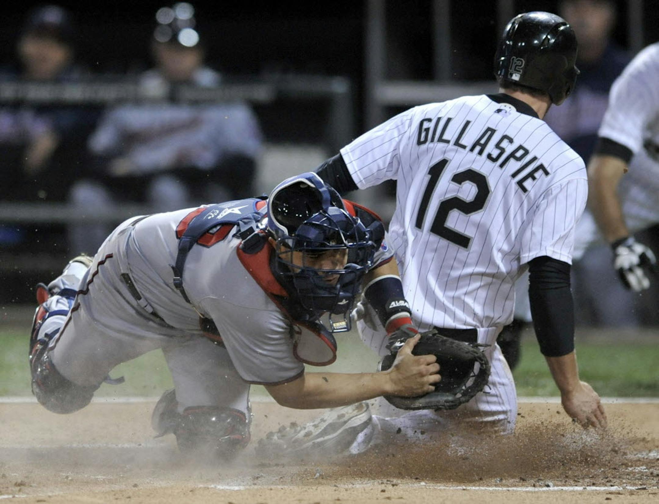 Twins catcher Josmil Pinto attempts to tag Chicago's Conor Gillaspie (12), as he slides safely into home plate on a Alexei Ramirez single during the first inning Monday.
