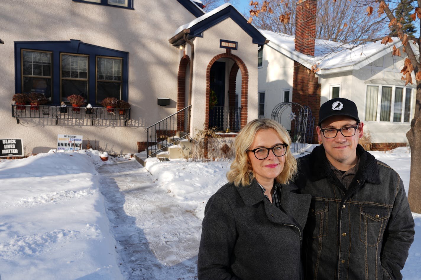 Mindy Travers and her husband Nathan Morales stand for a portrait in front of their home Friday, Dec. 30, 2022 in south Minneapolis. The couple are one of a few hundred city residents who went through a city program to remove a racial covenant that had existed on their property after it was built in the early 1900s. ] ANTHONY SOUFFLE • anthony.souffle@startribune.com