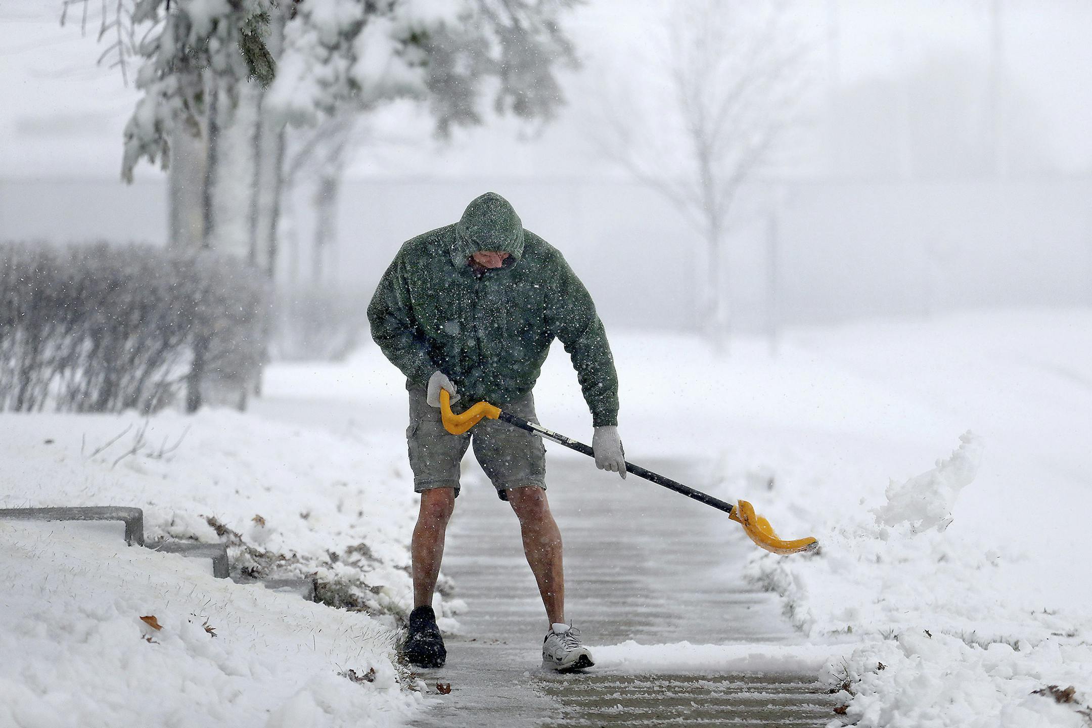 Peter Lidstone shovels his sidewalk during a snow storm, Friday, Nov. 18, 2016 in St. Cloud, Minn. The National Weather Service has issued a blizzard warning for Friday in eastern parts of North and South Dakota and Minnesota, as well as winter storm warnings for other parts of those states and Nebraska. ( Elizabeth Flores/Star Tribune via AP)