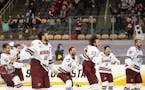 University of Massachusetts men's hockey players rush onto the ice to celebrate after defeating St. Cloud State 5-0 to claim the program's first natio